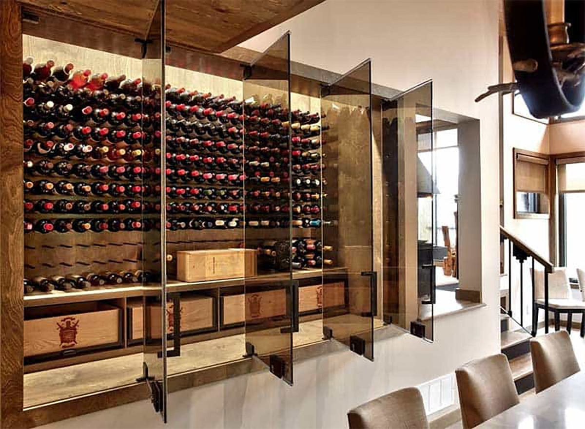 Glass wine enclosure with doors open showcasing many bottles of wine